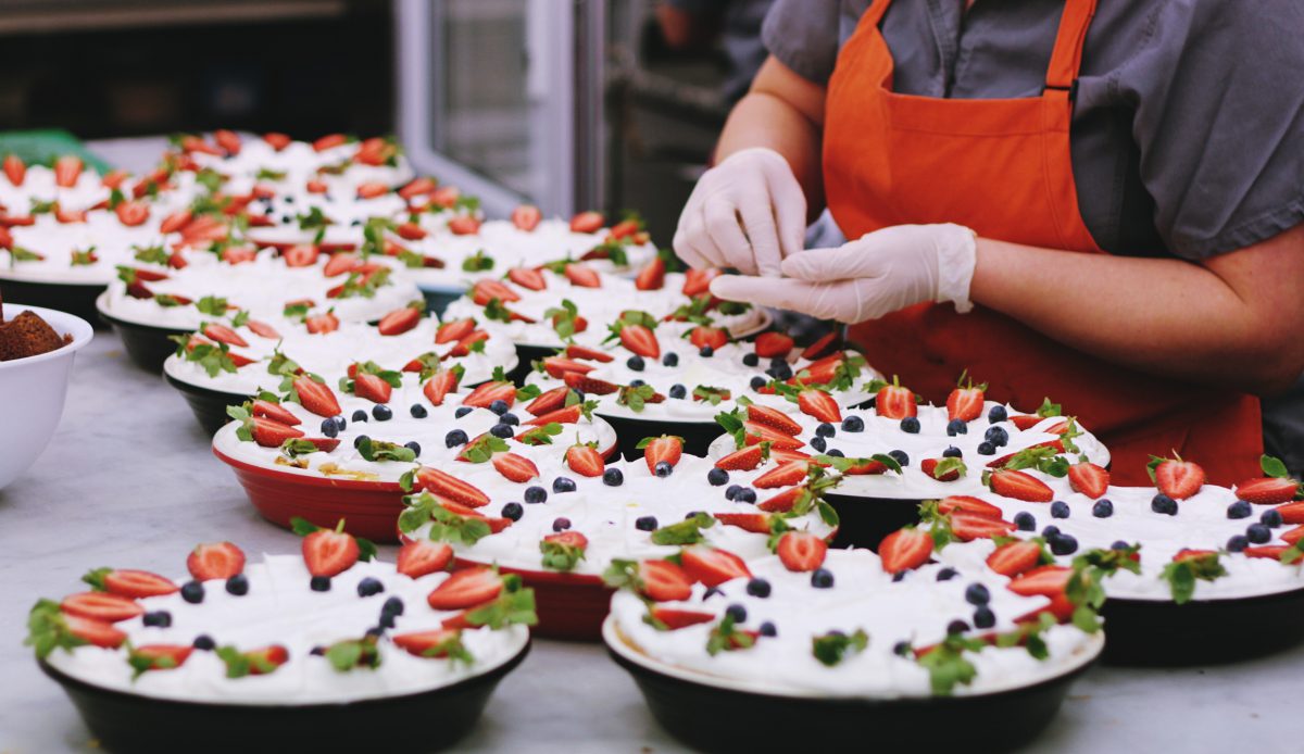 gloved hands prepare food