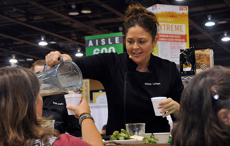 Chef Antonia pouring a drink for a visitor