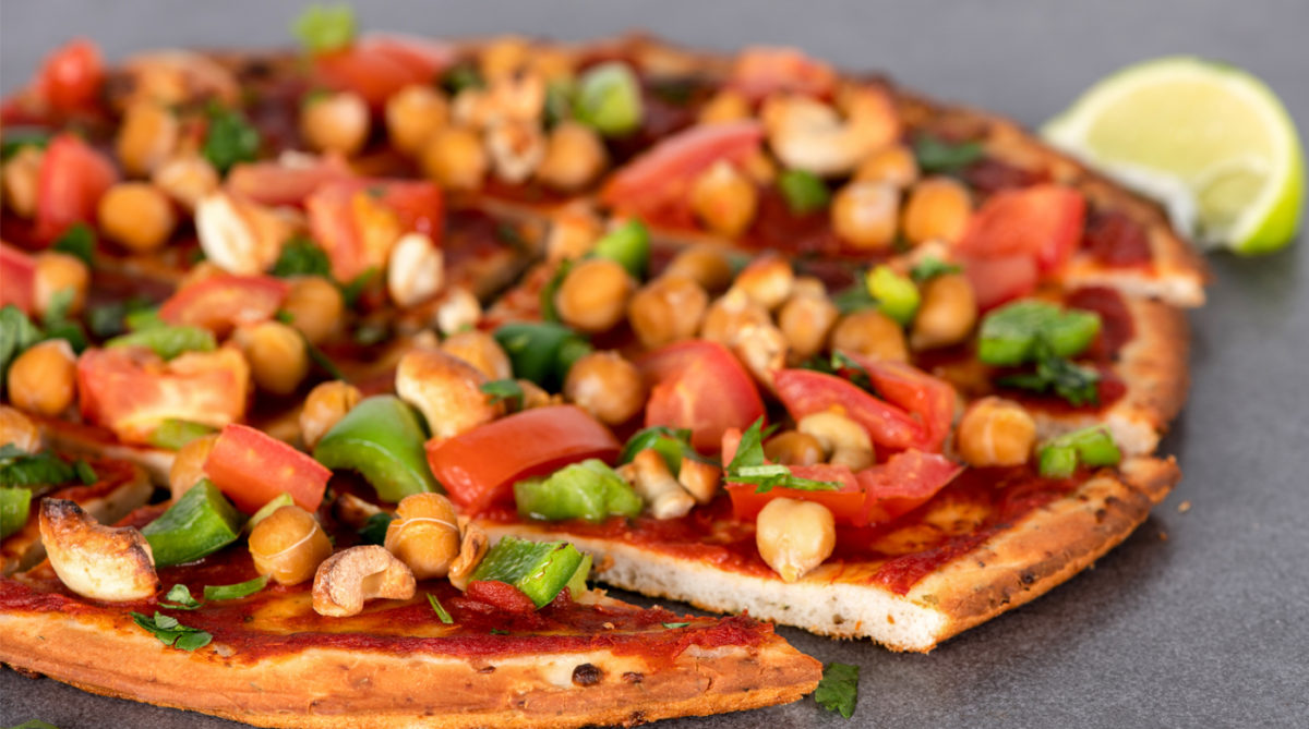 Califlower crust pizza topped with chickpeas and vegetables.