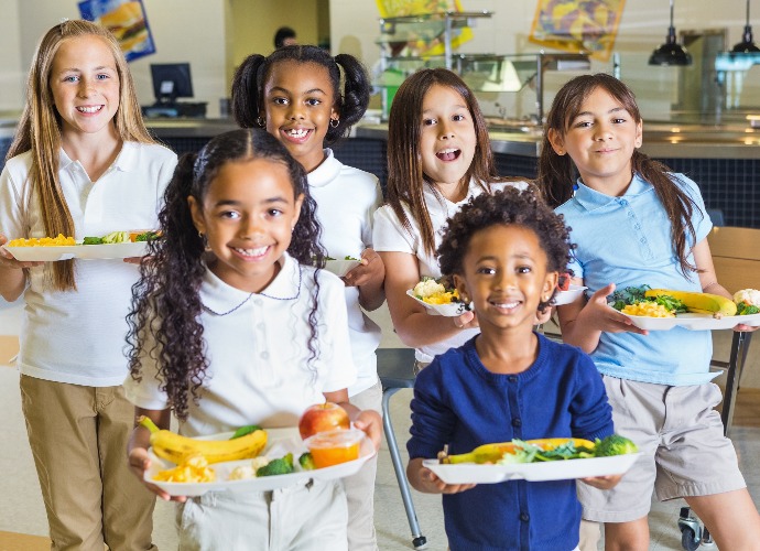 Group of young students holding lunch trays