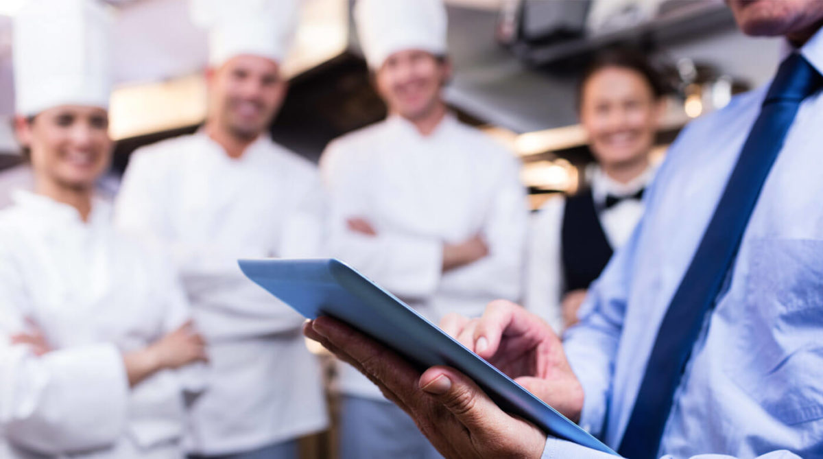 chef with iPad and kitchen staff
