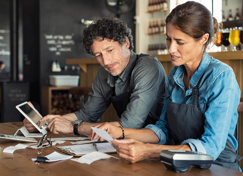 Two restaurant workers preparing paperwork