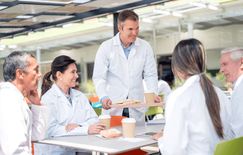 Healthcare professionals eating lunch in cafeteria