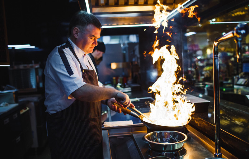 Cook in kitchen sautéing food