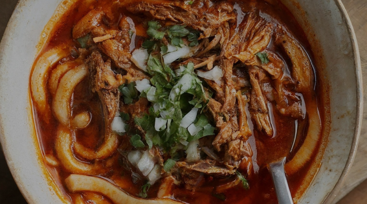 Juicy birria pork with udon noodles and rich ramen broth in a bowl