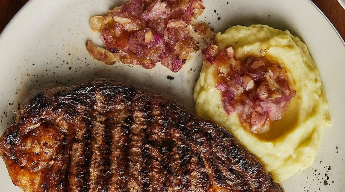 Roasted Premium Ribeye with Cracked Pepper Mashed Potatoes and Three-Onion Relish on a plate