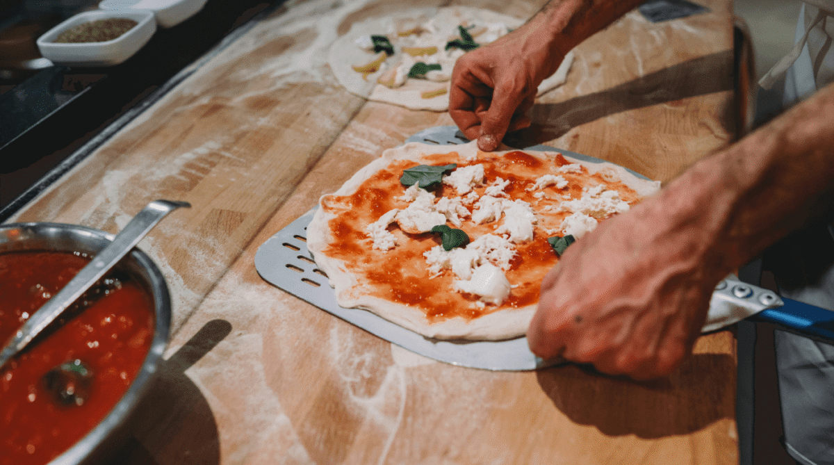 Chef making pizza on a wooden countertop